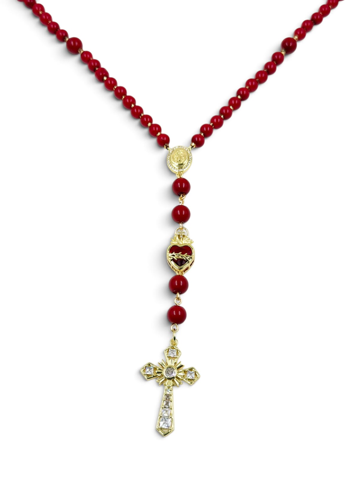 Collar de cuentas con dijes religiosos, corazón y cruz decorativa.