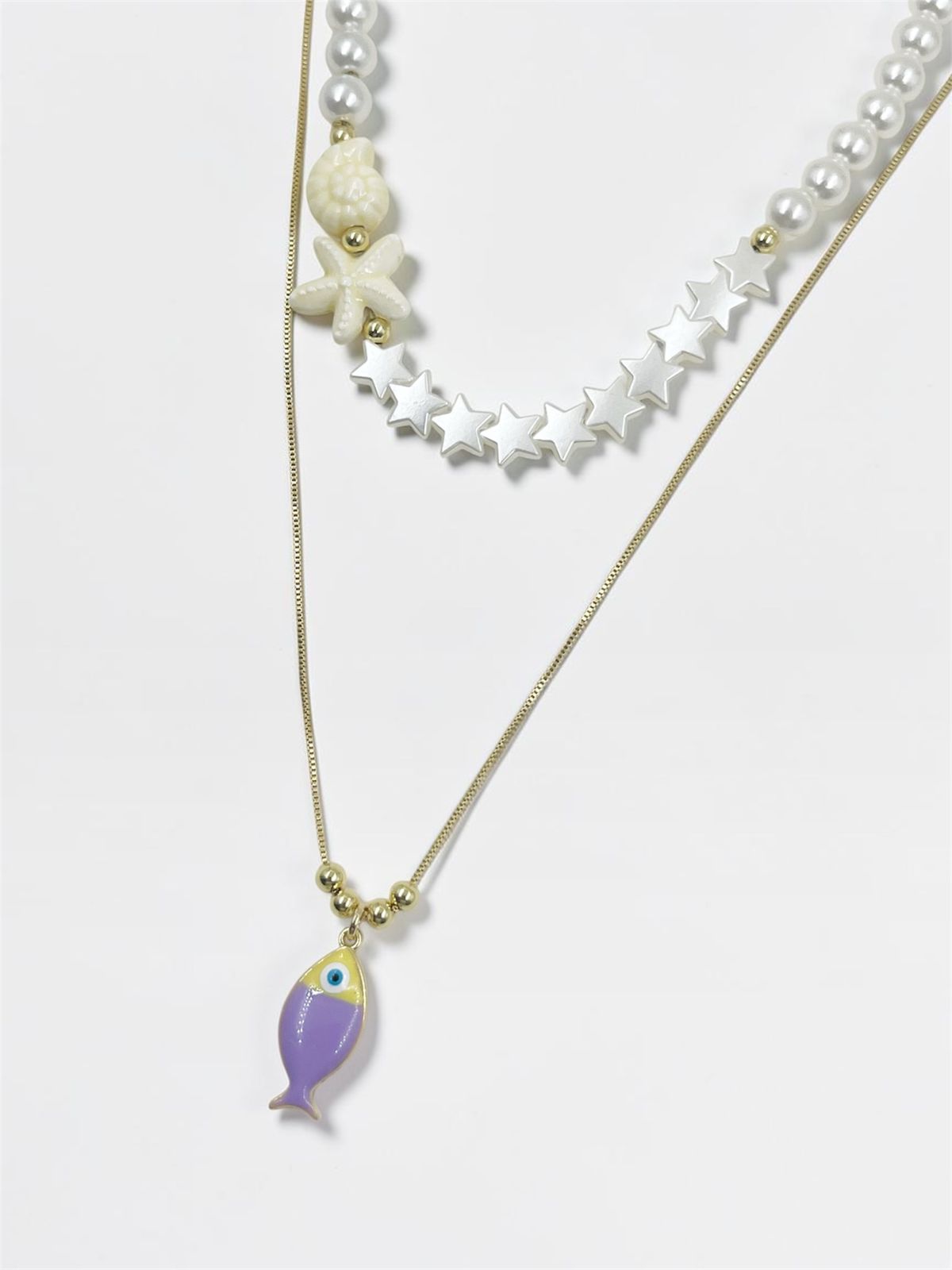 Collar Fishes Pearl de doble capa con perlas esmaltadas, estrellas perladas y dije de pez inspirado en el mar.