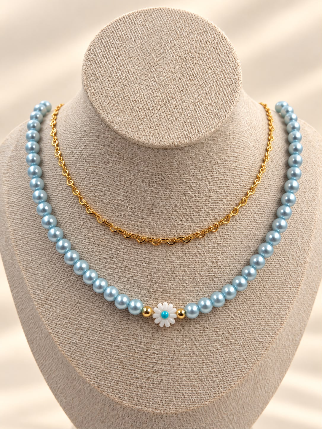 Collar de doble cadena con detalle de margarita y diseño delicado.