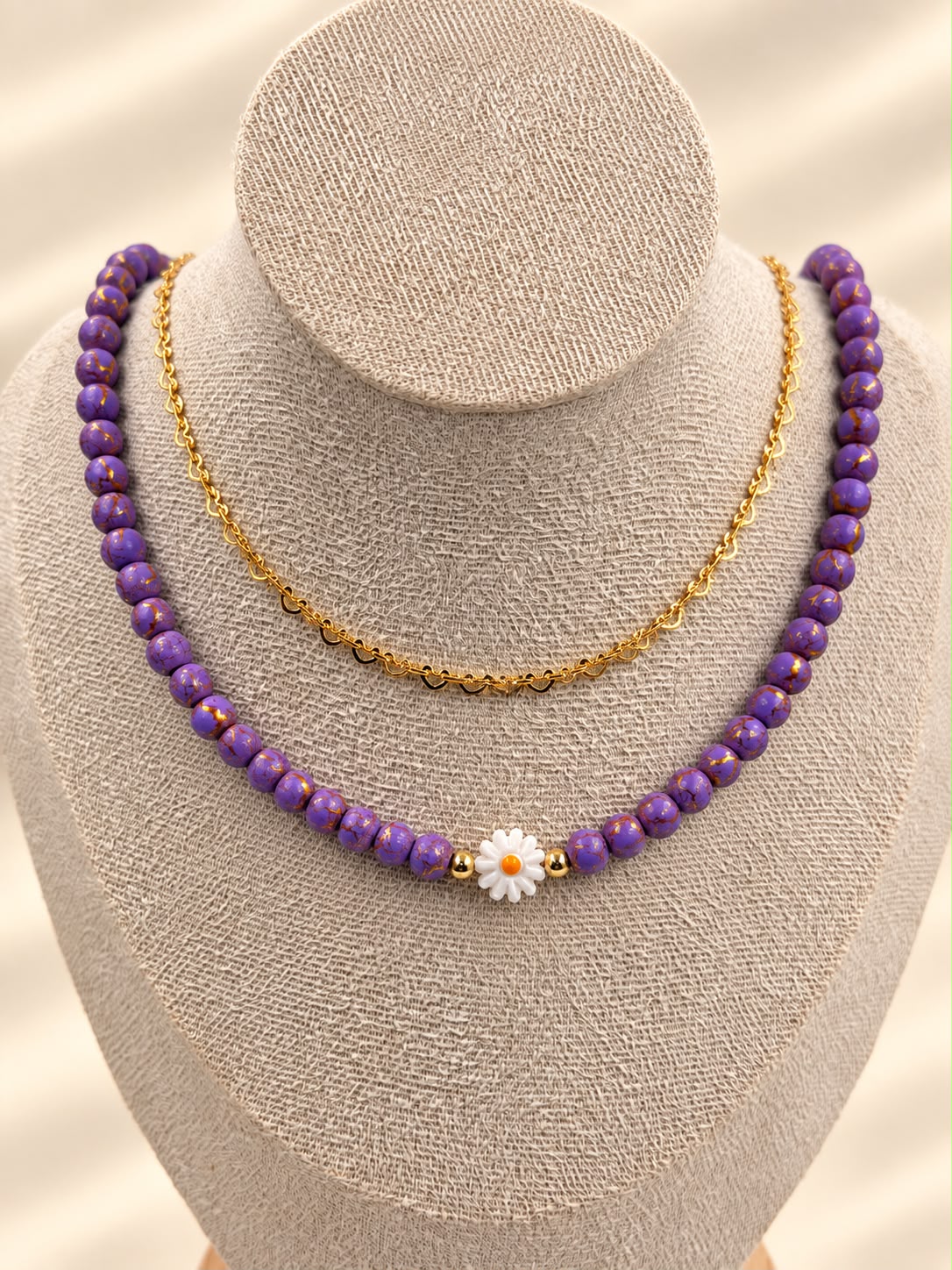 Collar de doble cadena con detalle de margarita y diseño delicado.