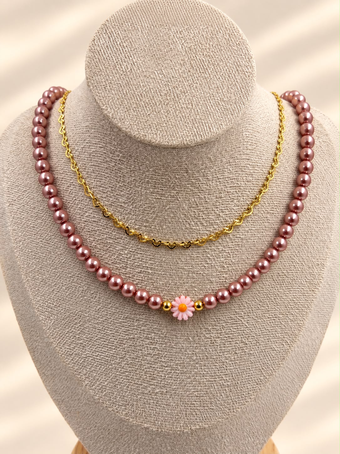 Collar de doble cadena con detalle de margarita y diseño delicado.