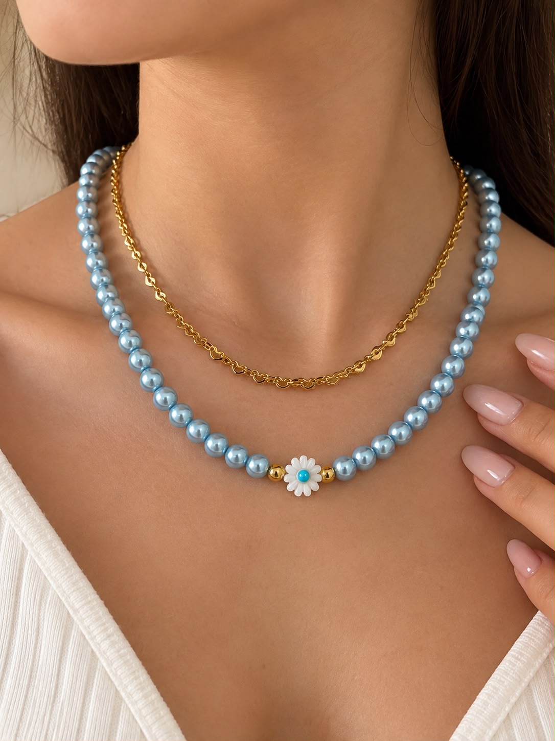 Collar de doble cadena con detalle de margarita y diseño delicado.