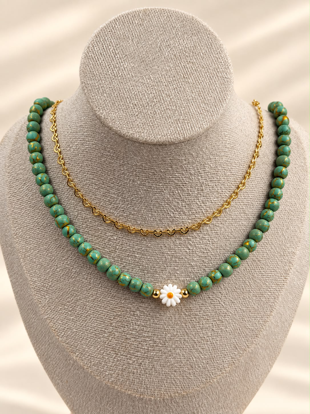 Collar de doble cadena con detalle de margarita y diseño delicado.