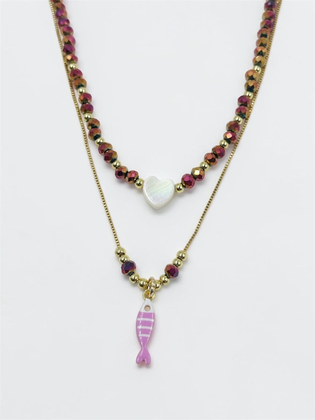 Set de dos collares con choker de cuentas y dije de corazón, acompañado de un collar largo con dije de pez para mujer.