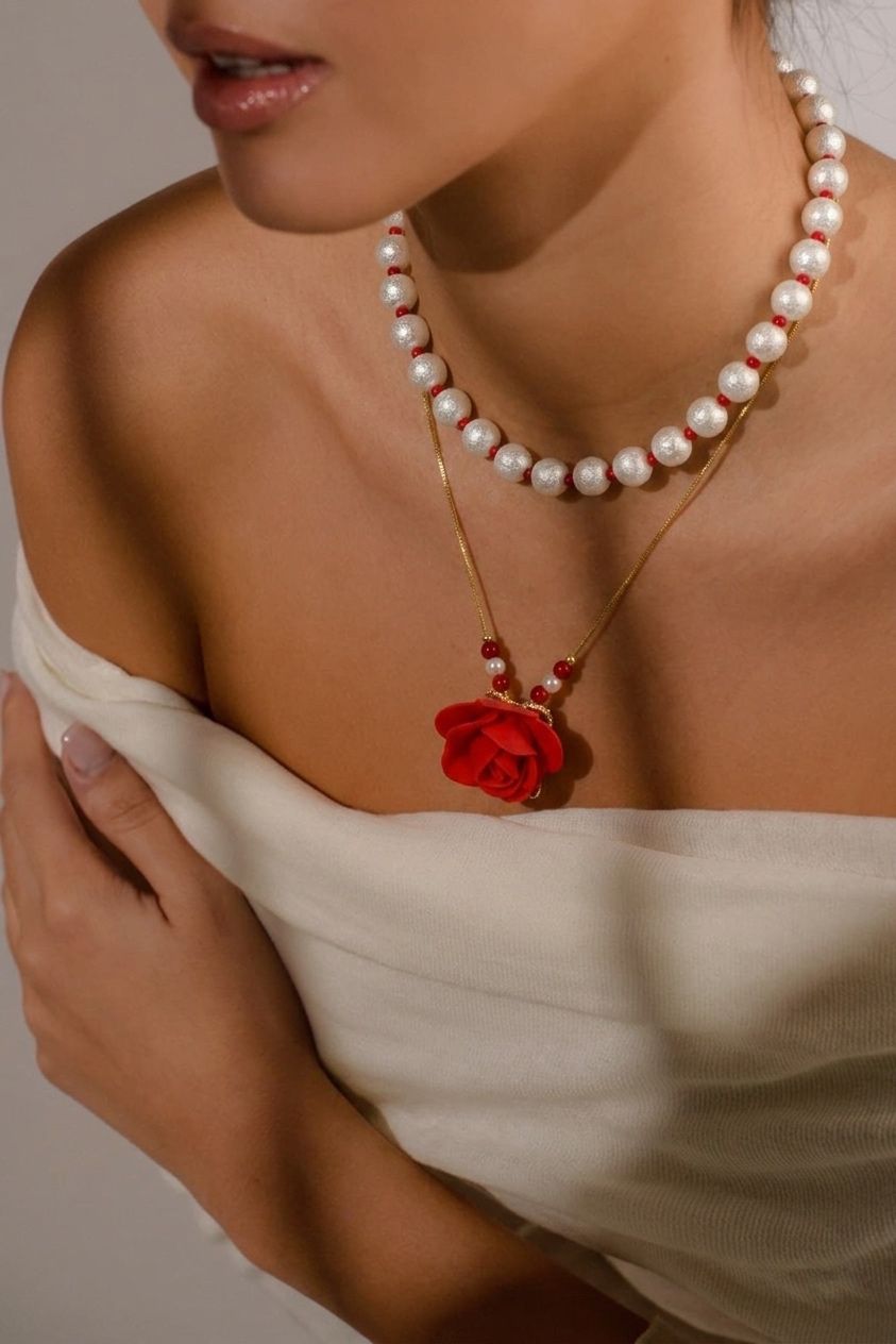 Collar Rosa Perlada de doble diseño con dije de rosa en relieve, ideal para complementar looks elegantes y casuales.