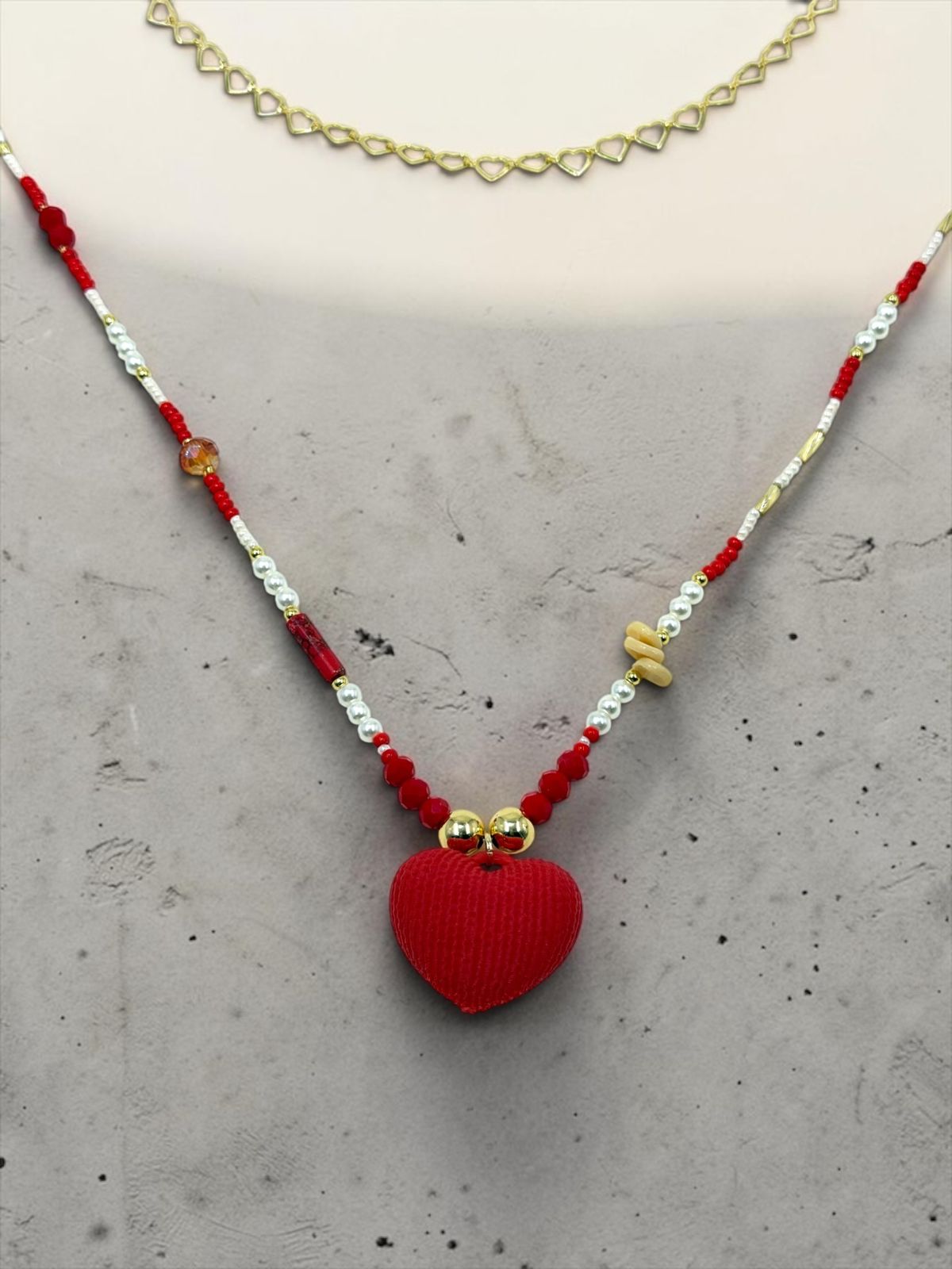 Collar de cuentas con detalles decorativos y dije de corazón.