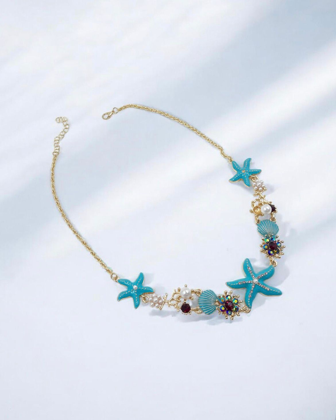 Collar Oceánico Turquesa con estrellas, conchas marinas y detalles perlados inspirado en el océano.