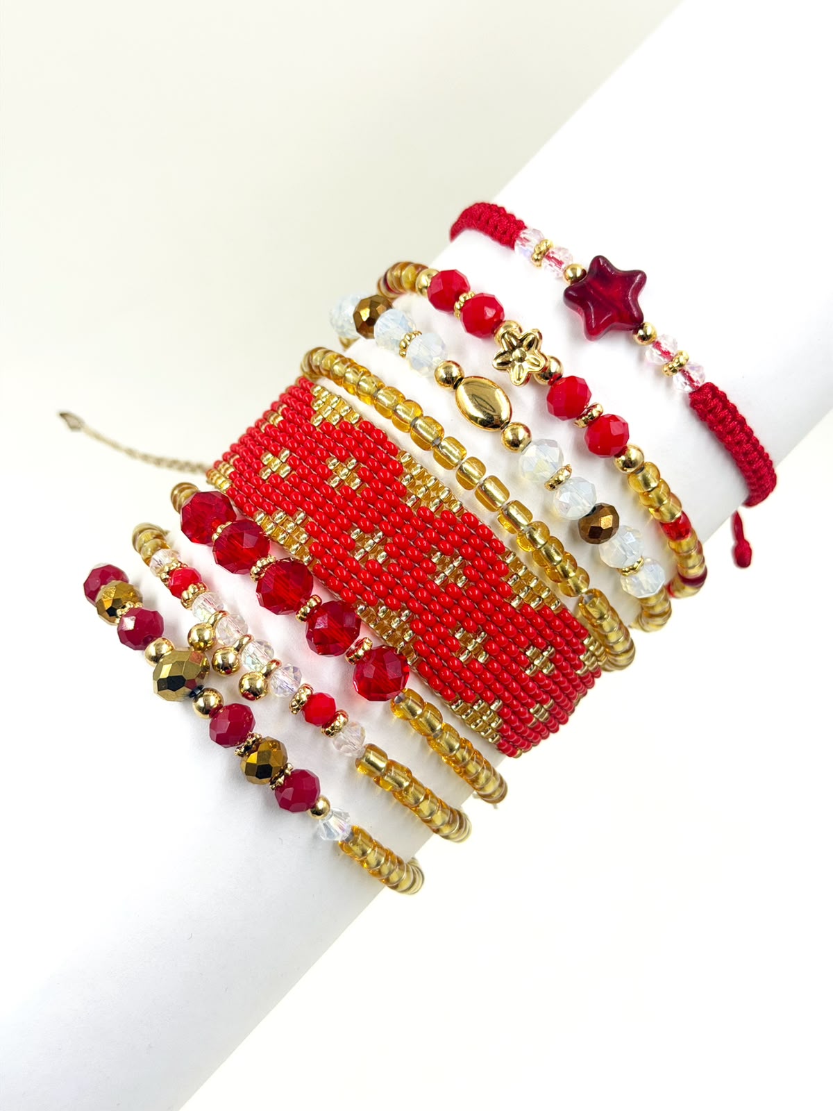 Maxipulsera de 8 vueltas con banda central tejida en patrón de rombos, cuentas facetadas, esferas y detalles geométricos.