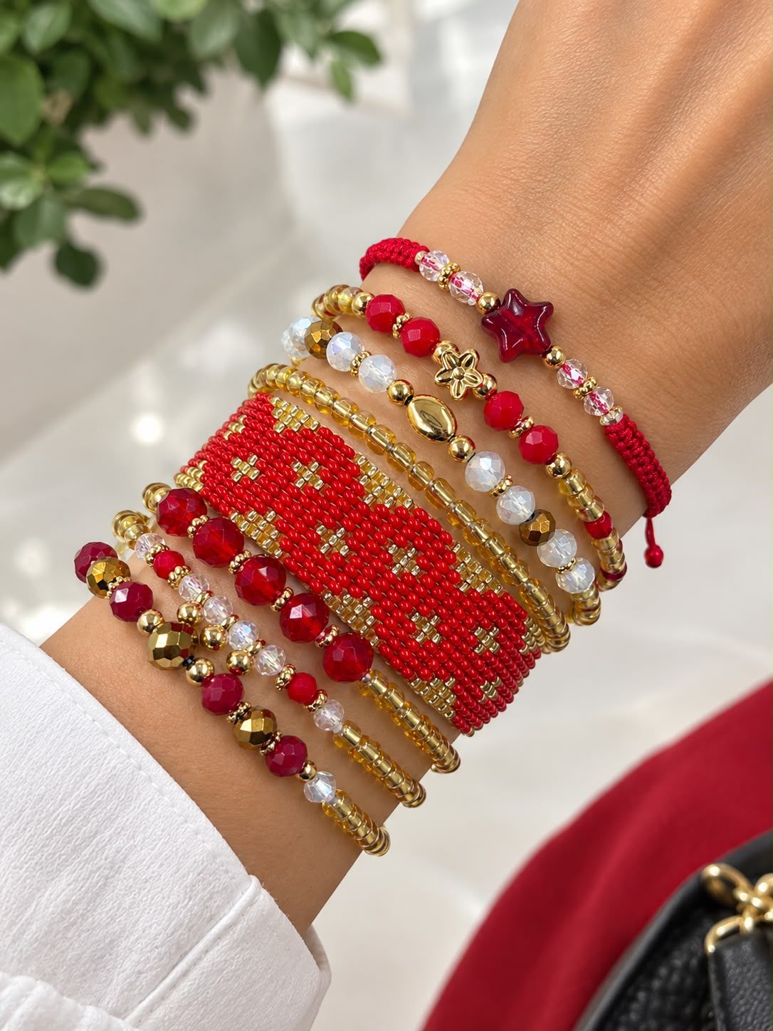 Maxipulsera de 8 vueltas con banda central tejida en patrón de rombos, cuentas facetadas, esferas y detalles geométricos.