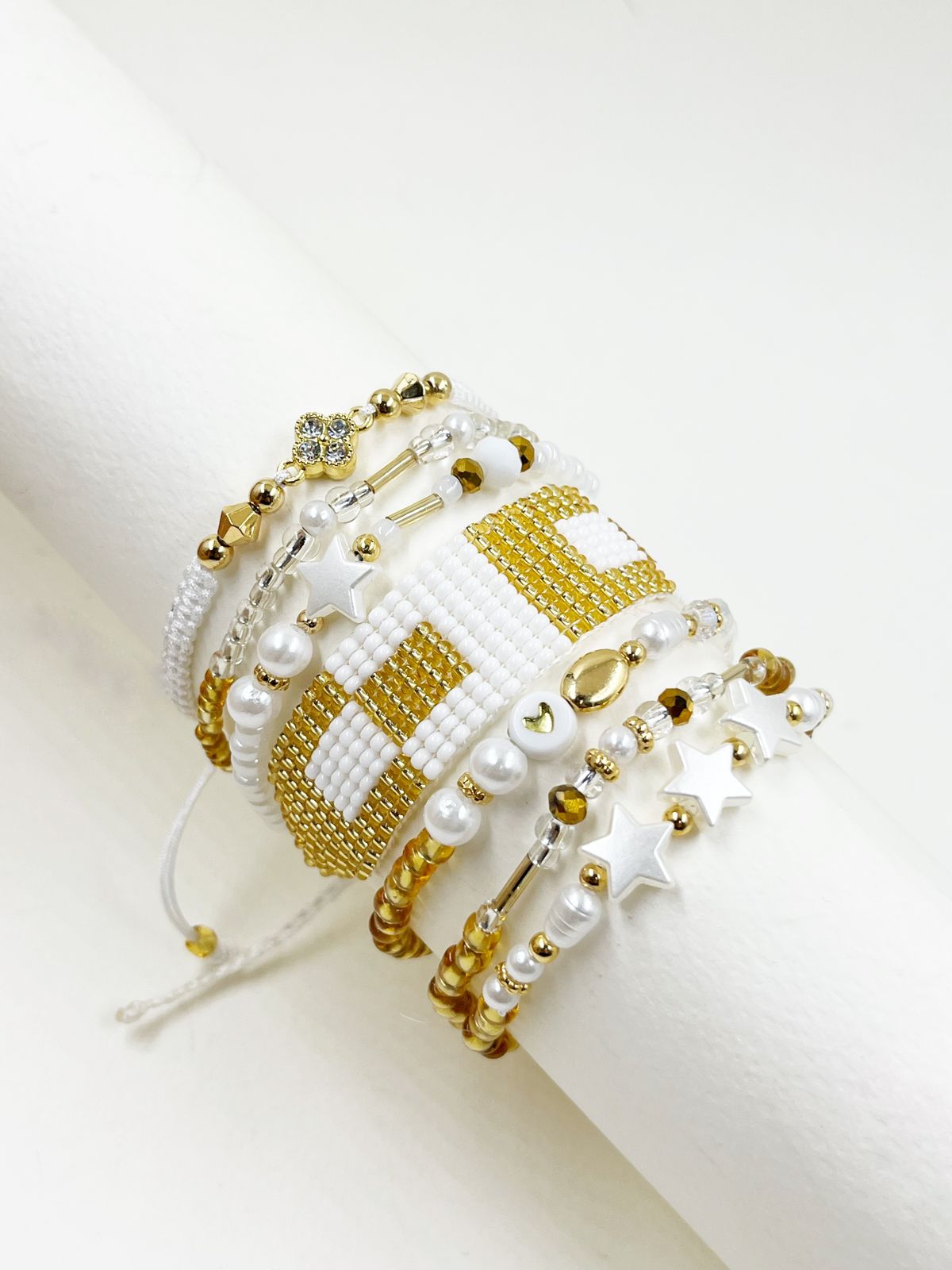 Maxipulsera Sensación Gold White con múltiples vueltas, estrellas decorativas, corazones y tejido artesanal para mujer.
