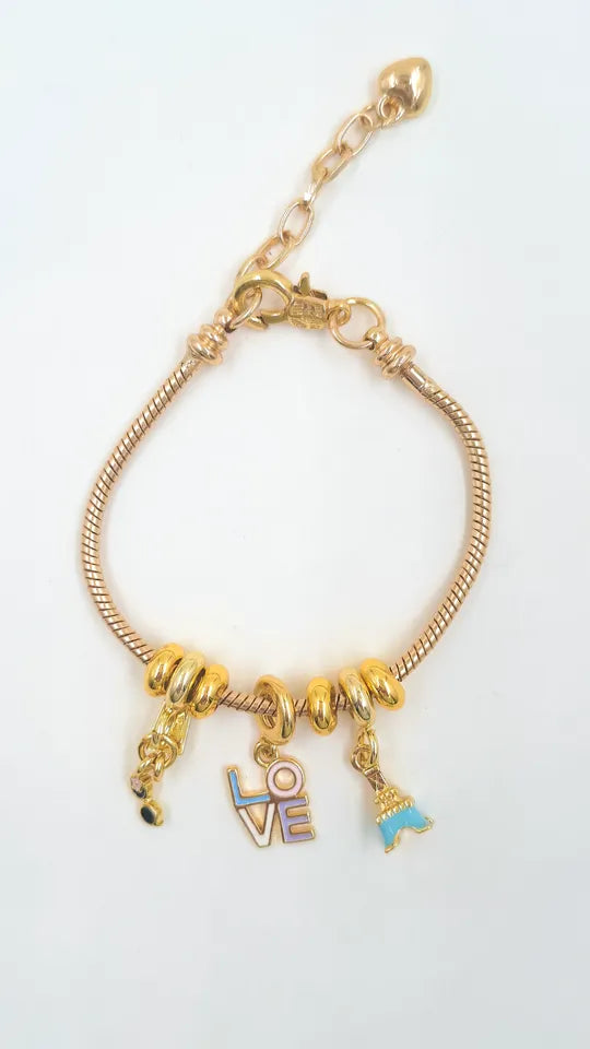 Pulsera Charms Torre Love en guaya dorada con dijes rodinados pintados y lacados.