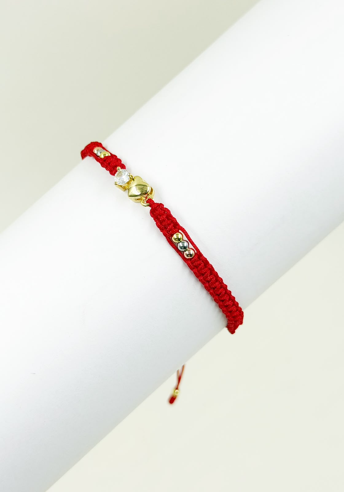 Pulsera artesanal con dije de corazón inflado y detalle central brillante.