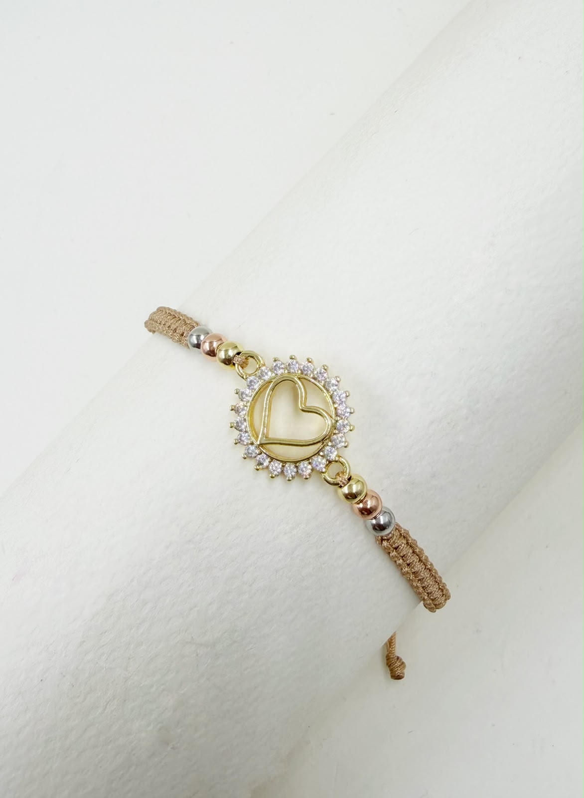 Pulsera artesanal con dije de corazón calado y detalles brillantes, de diseño delicado y romántico.