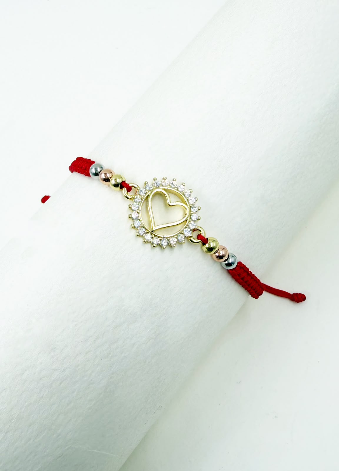 Pulsera artesanal con dije de corazón calado y detalles brillantes, de diseño delicado y romántico.