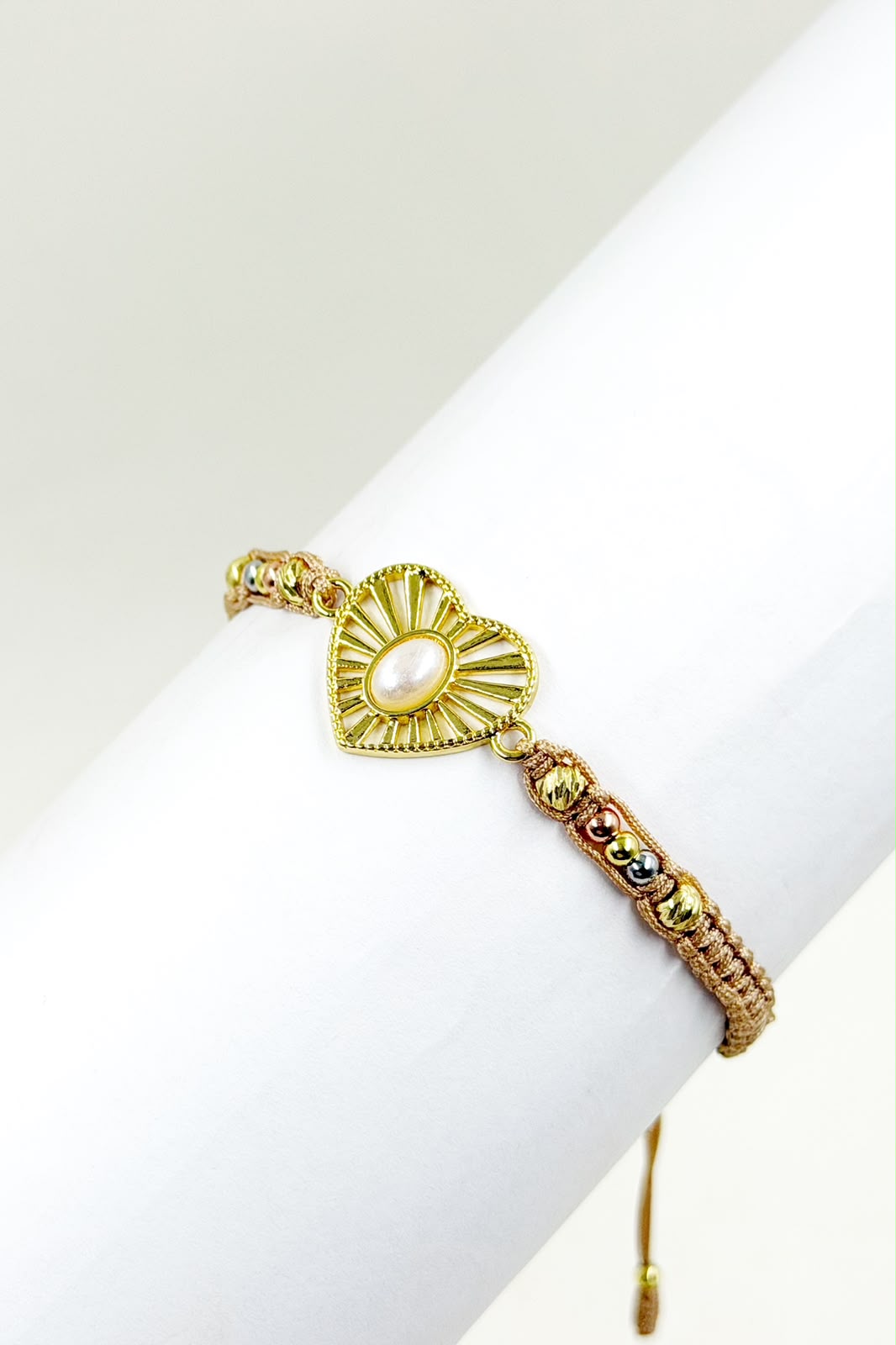 Pulsera artesanal con diseño de corazón calado y detalle central, de estilo delicado y romántico.