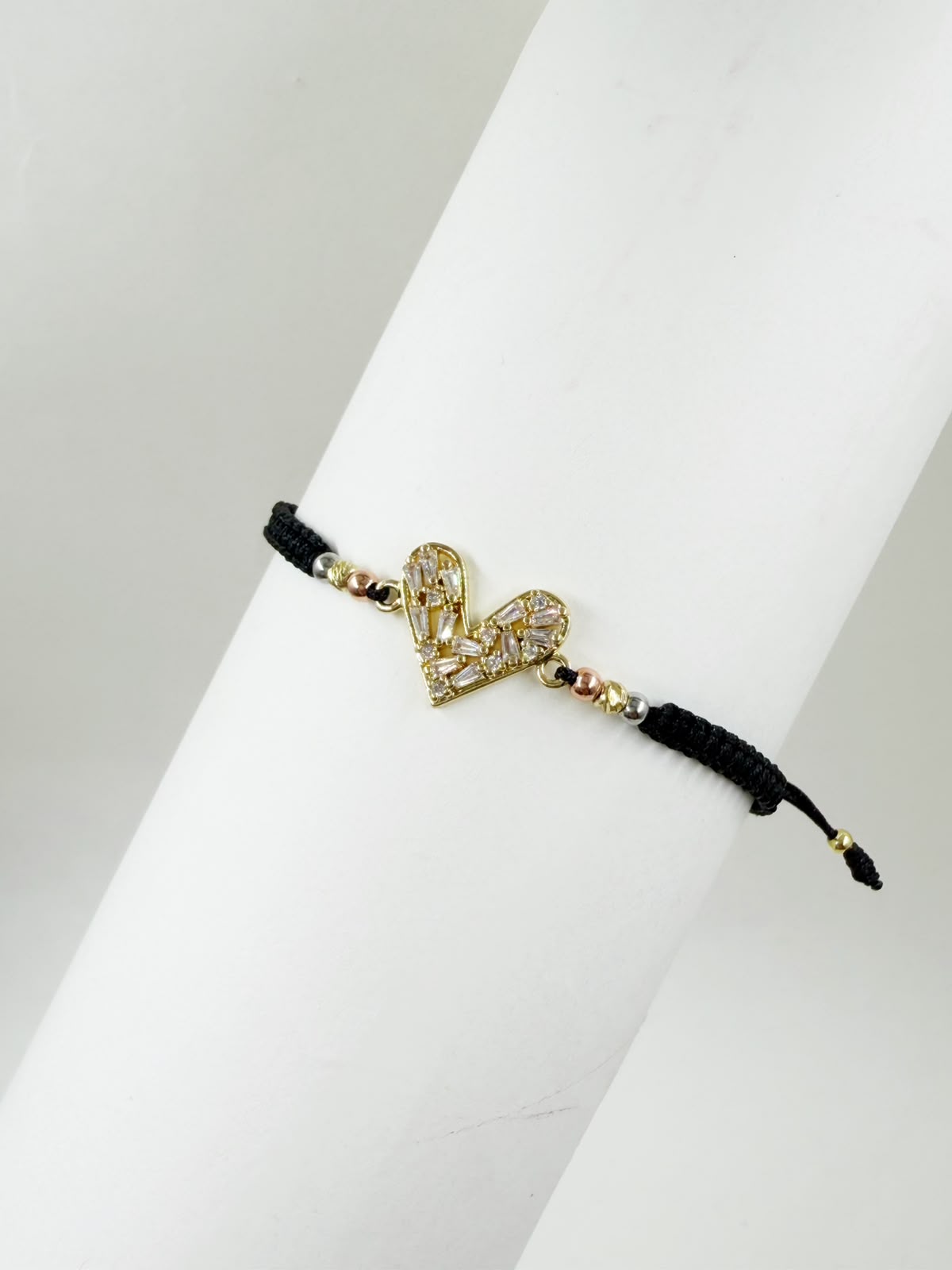 Pulsera artesanal con corazón calado decorado con detalles brillantes y diseño elegante.