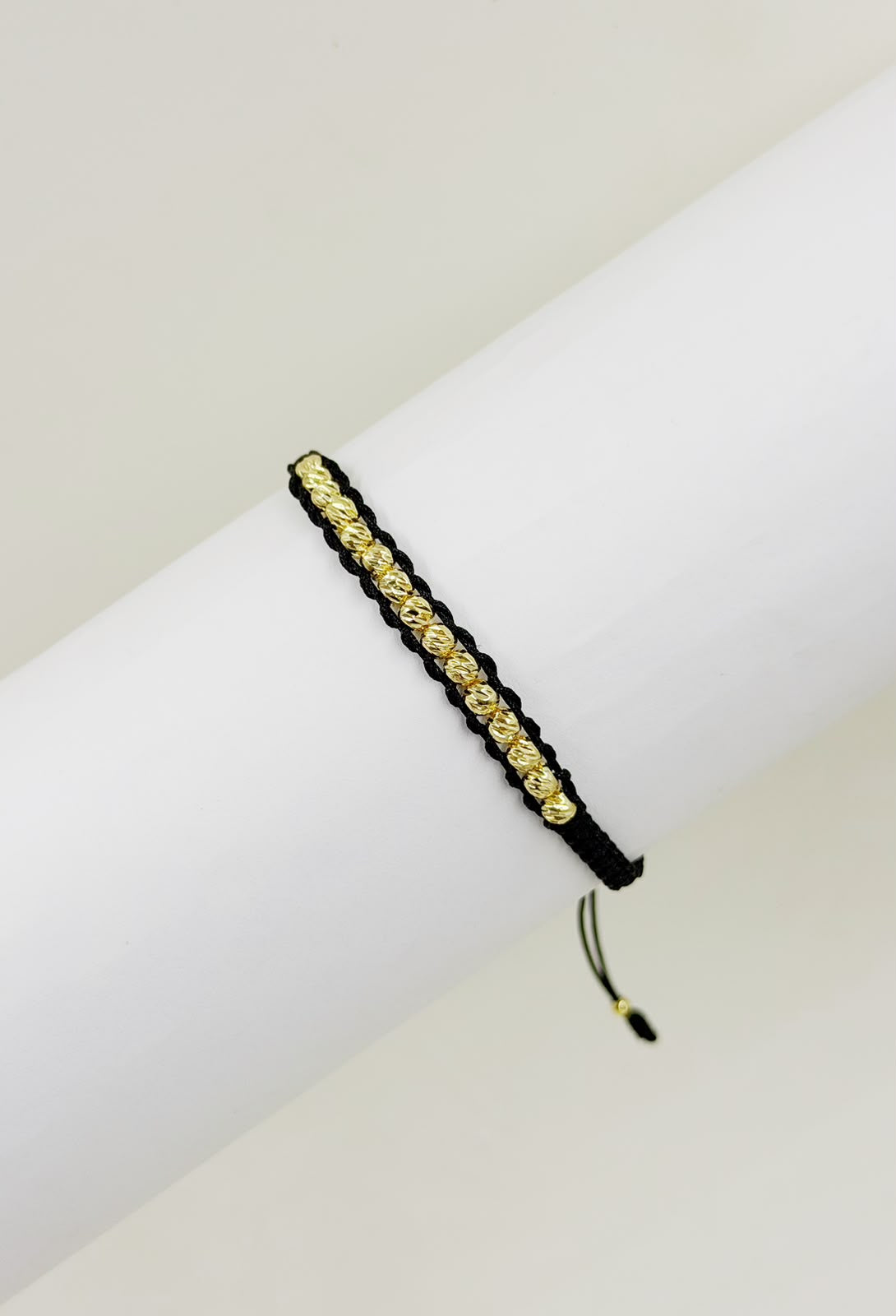 Pulsera artesanal de diseño minimalista con detalles decorativos en los extremos.
