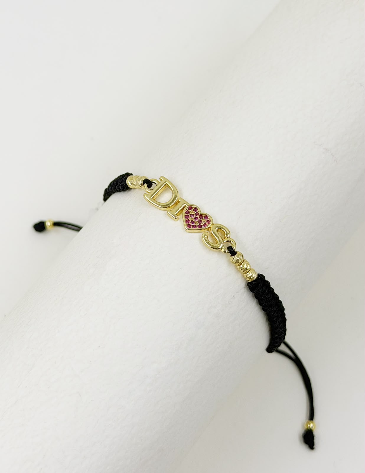 Pulsera artesanal sencilla con dije que lleva la palabra Dios, de diseño delicado y significativo.