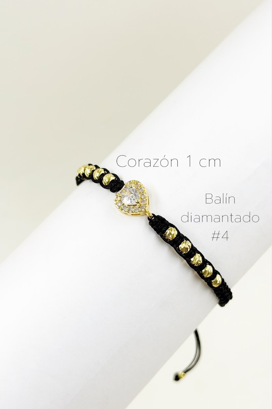 Pulsera artesanal con dije de corazón y detalle central tipo perla, de diseño delicado y romántico.
