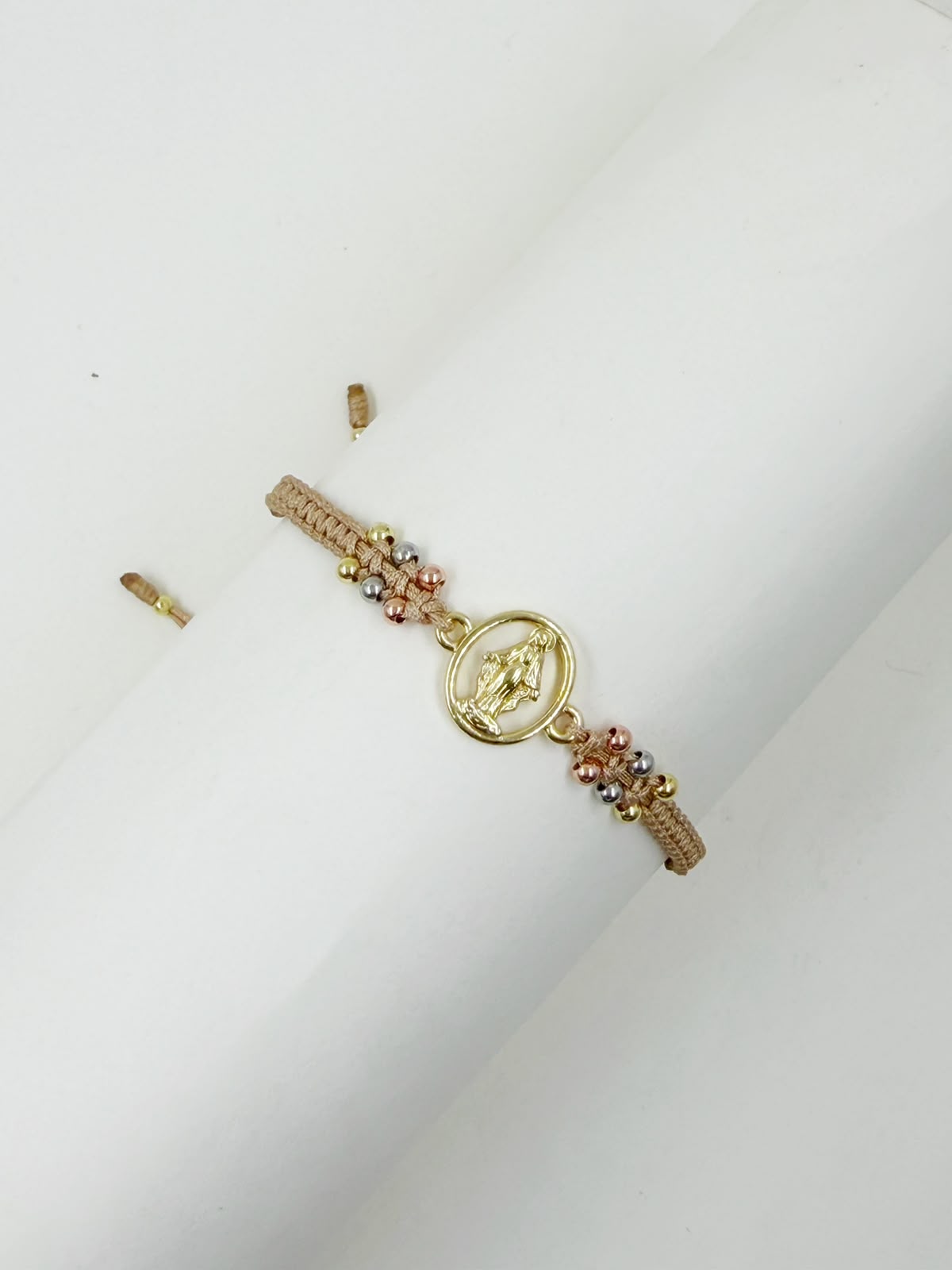 Pulsera artesanal con dije de la Virgen de la Milagrosa, de diseño calado y delicado.