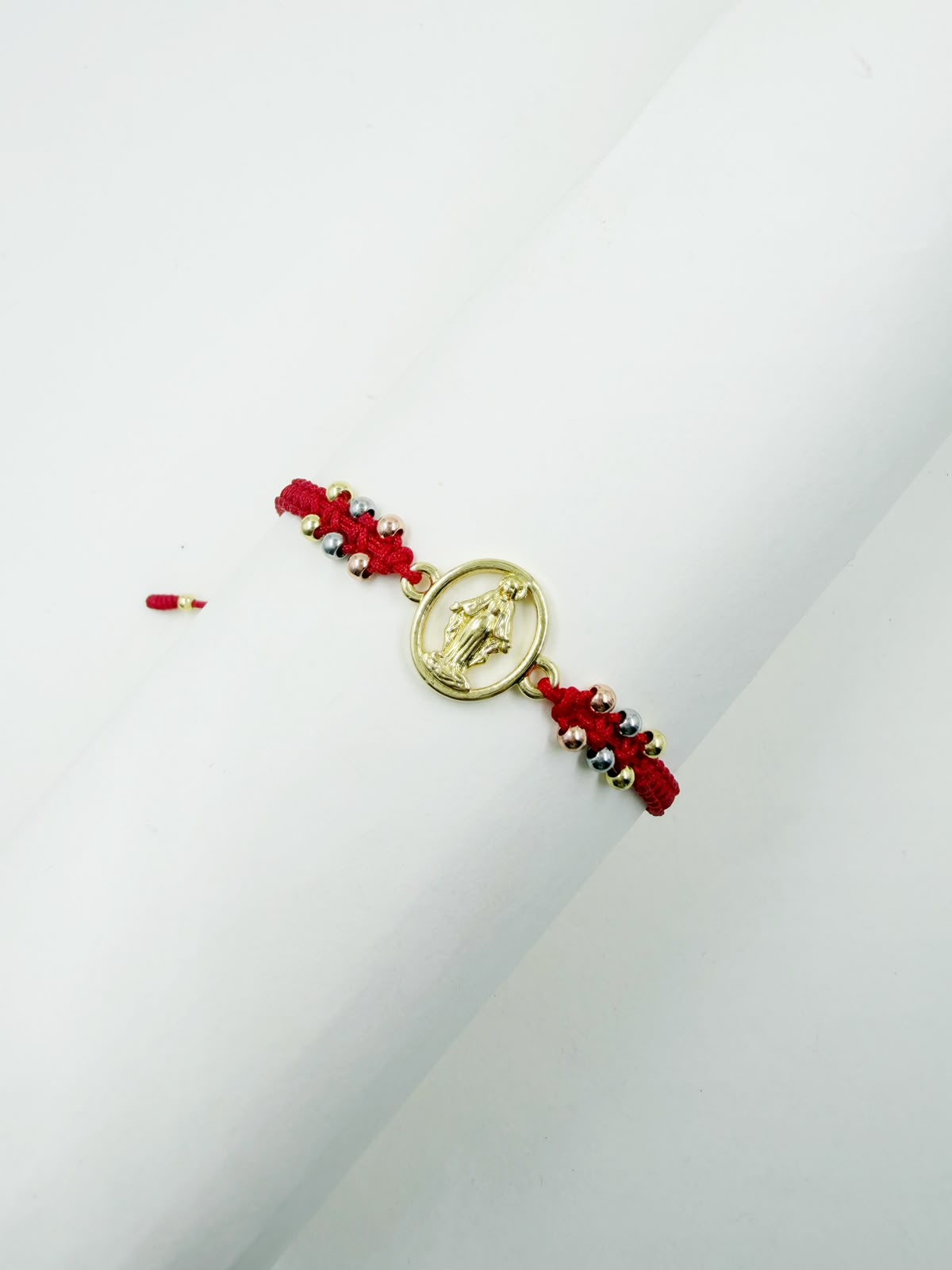 Pulsera artesanal con dije de la Virgen de la Milagrosa, de diseño calado y delicado.