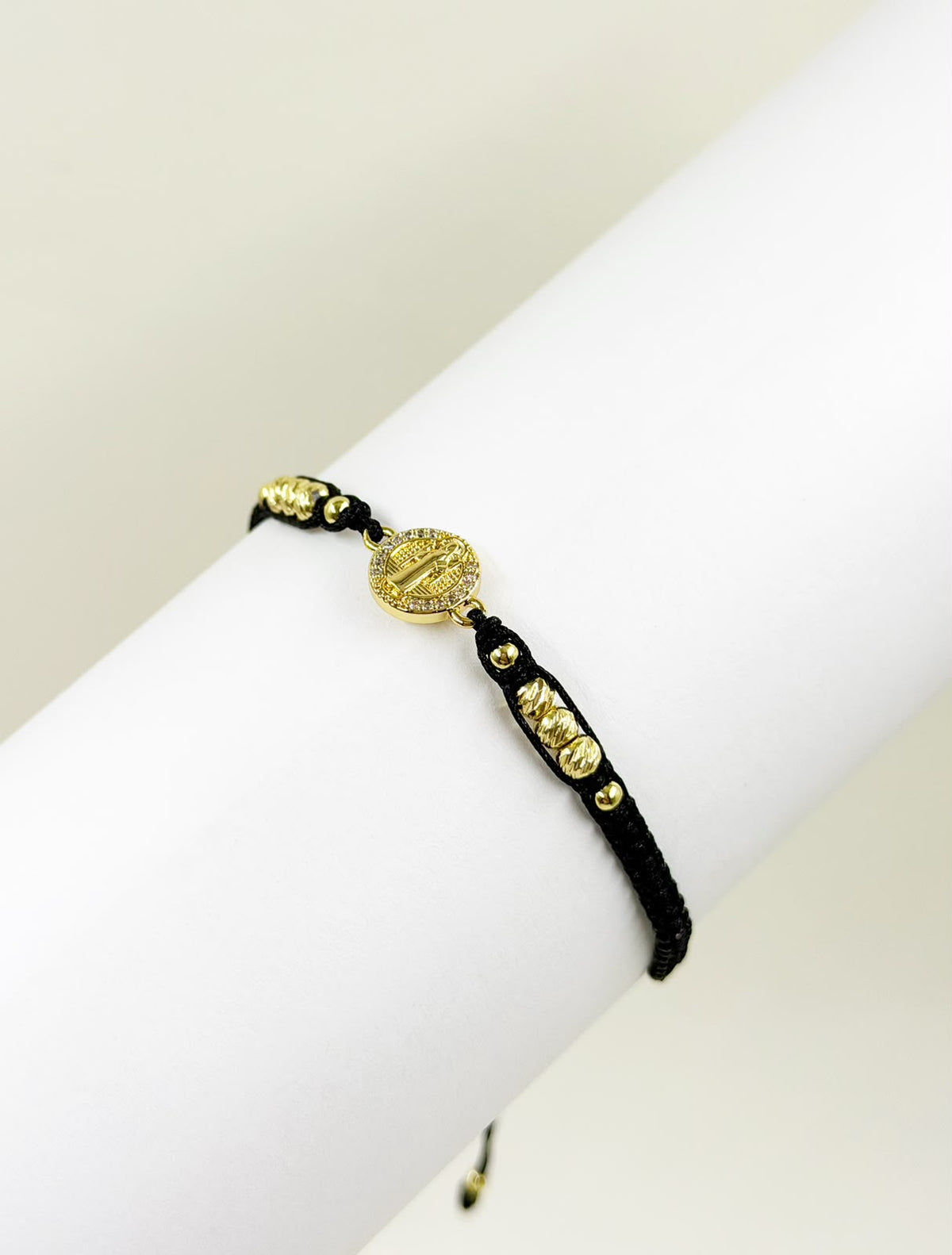 Pulsera artesanal con dije de San Benito, de diseño sencillo, delicado y elegante.