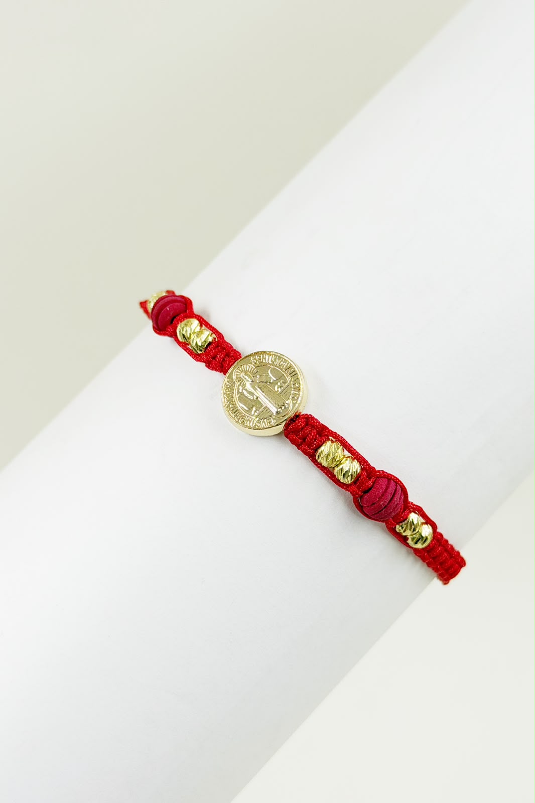 Pulsera artesanal sencilla con dije de San Benito y diseño minimalista.