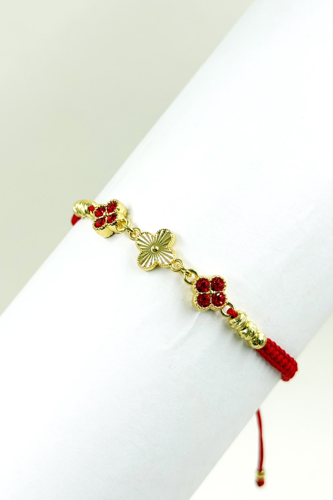 Pulsera artesanal con tres tréboles de cuatro hojas y diseño delicado.