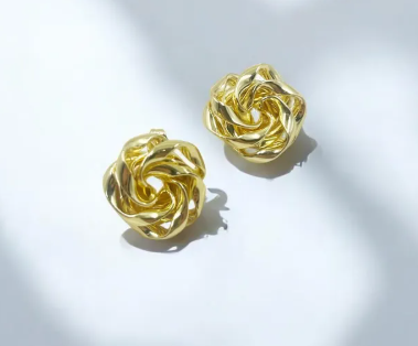 Aretes dorados tipo topo con forma de rosa esculpida en relieve tridimensional.