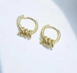 Aretes tipo candonga dorada con diseño geométrico en forma de espiral y acabado liso pulido.