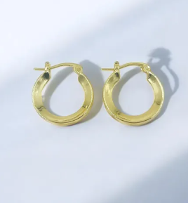 Aretes tipo candonga tubular dorada de silueta gruesa y acabado liso brillante y pulido.
