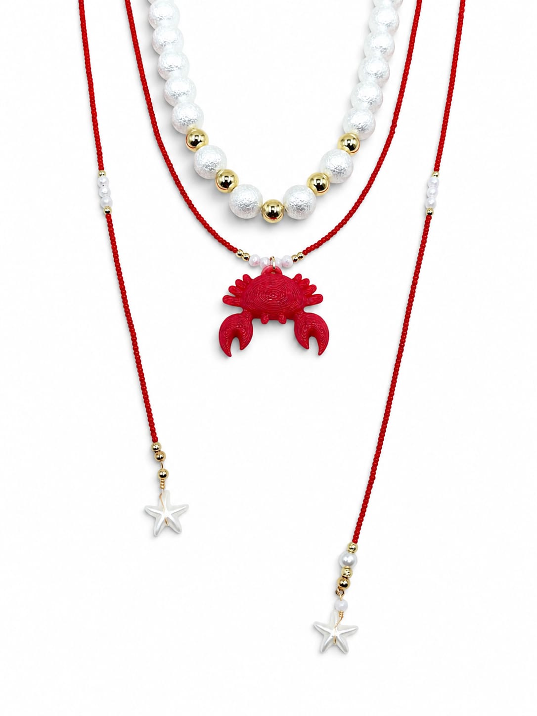 Collar Aurora Marina en tonos rojo, blanco y dorado, con diseño de choker y corbatín largo, detalles perlados y dije decorativo en el centro.