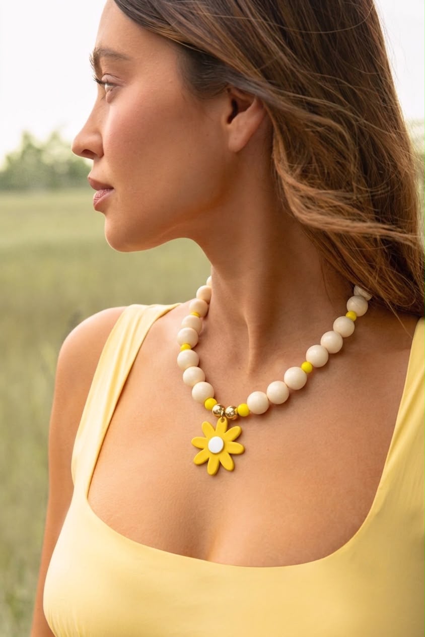 Collar chunky en tonos beige con detalles amarillos y dije de margarita, ideal para un estilo fresco y moderno.