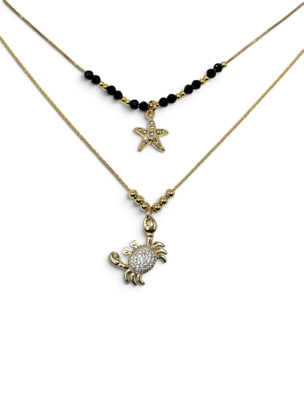 Set de dos collares con detalles decorativos y dijes de estrella y cangrejo.