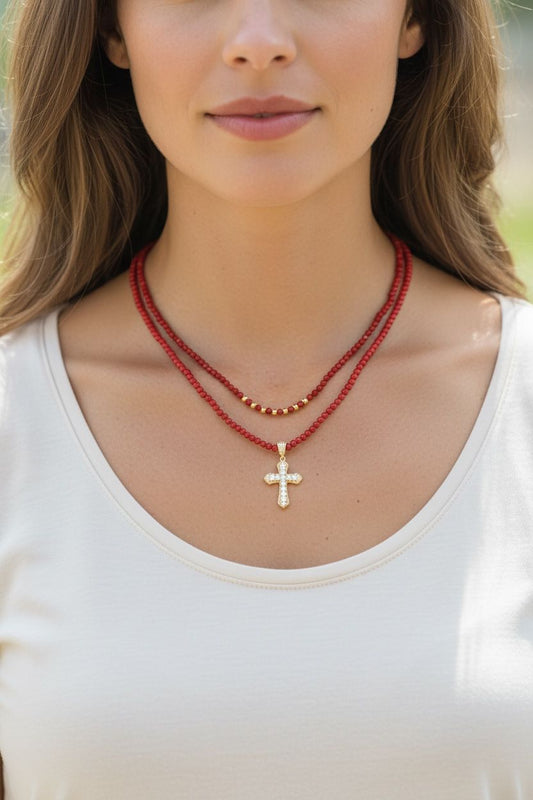 Set de dos collares con cuentas, cristales, detalles dorados y dije de cruz.