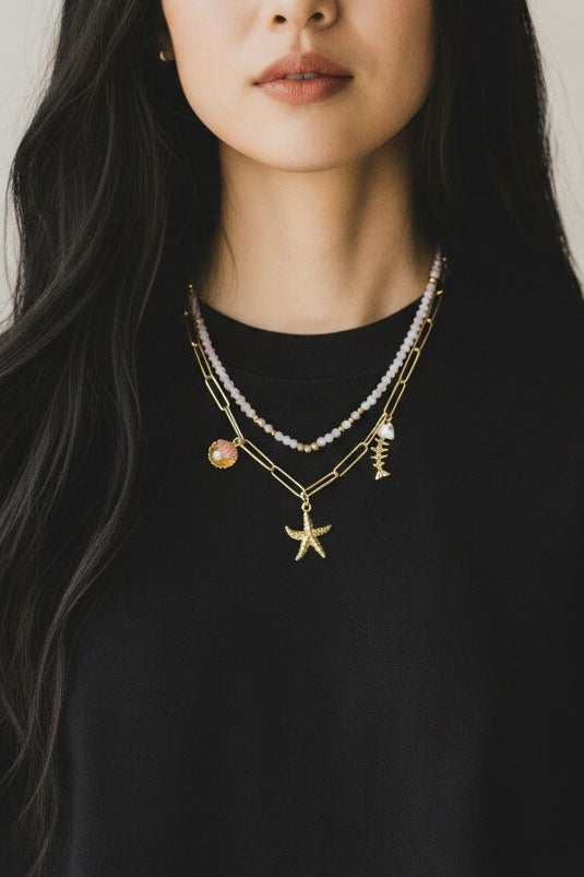 Set de dos collares con cristales facetados, cadena de eslabones y dijes marinos.