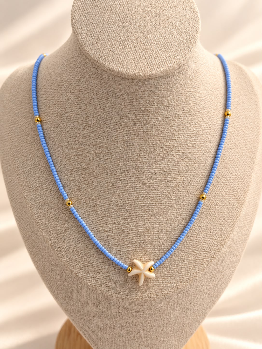 Collar de cuentas con dije central en forma de estrella de mar.