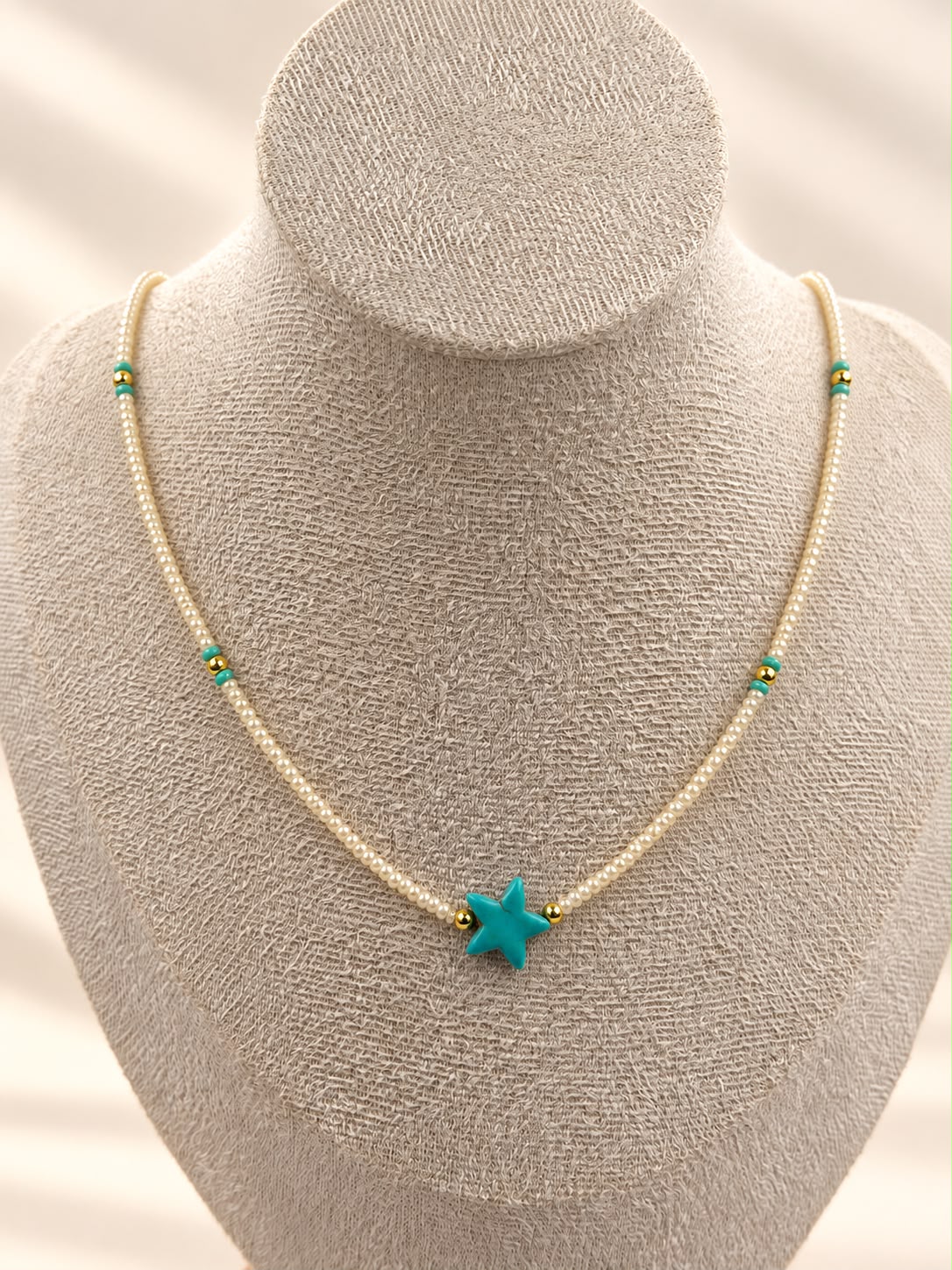 Collar de cuentas con dije central en forma de estrella de mar.