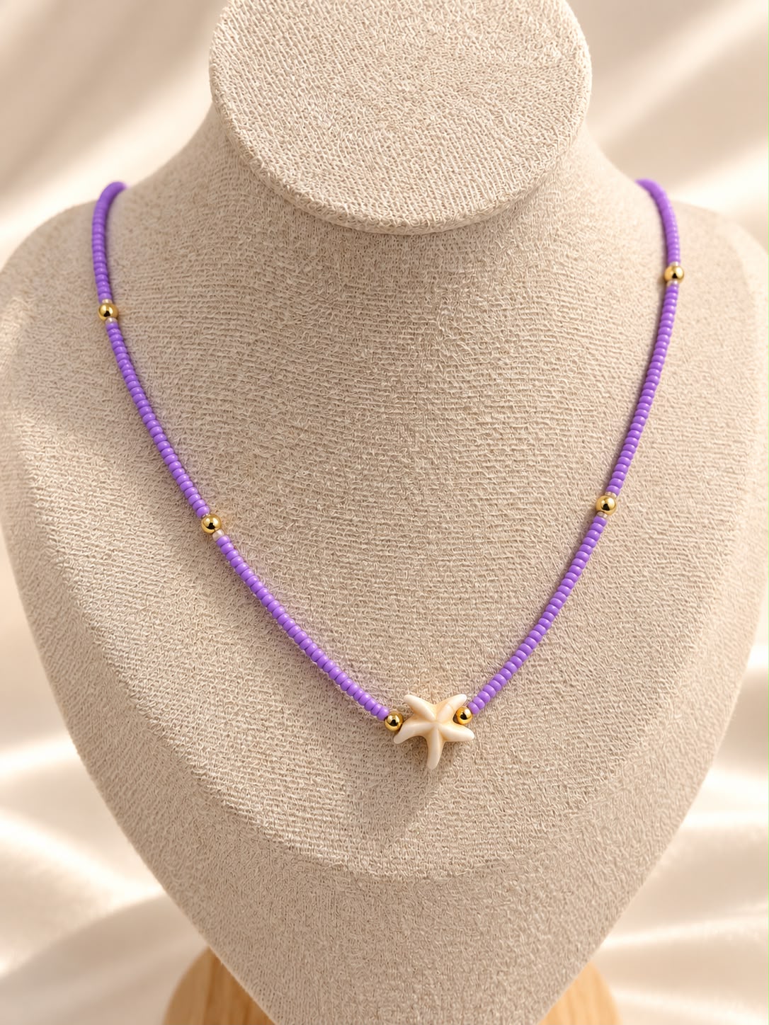Collar de cuentas con dije central en forma de estrella de mar.