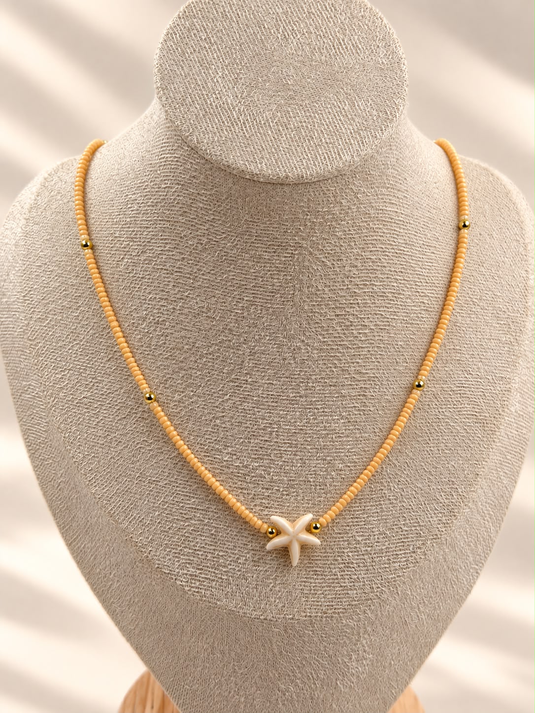 Collar de cuentas con dije central en forma de estrella de mar.