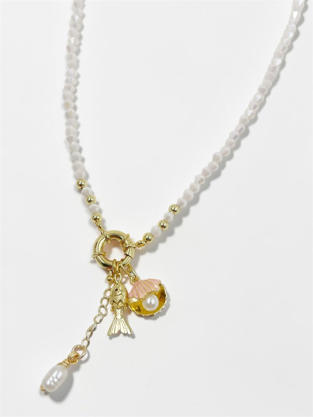 Collar Marea Costera con dije de concha, pez articulado y detalles perlados inspirados en el océano.