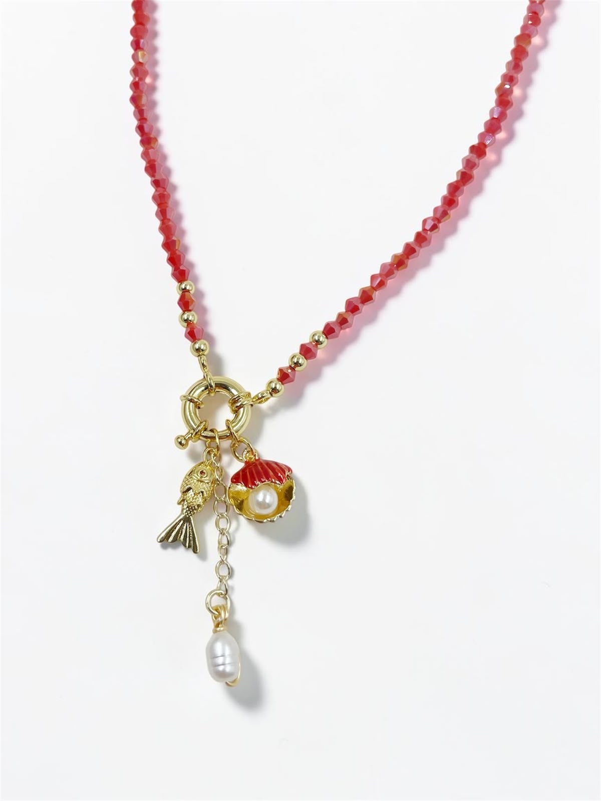 Collar Marea Costera con dije de concha, pez articulado y detalles perlados inspirados en el océano.