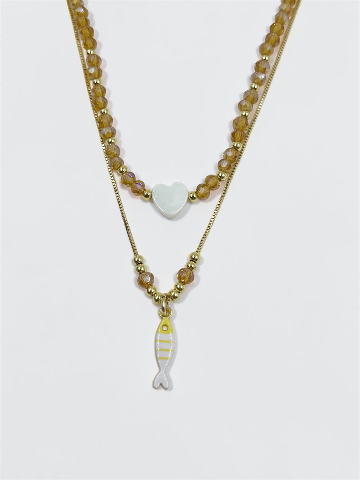 Set de dos collares con choker de cuentas y dije de corazón, acompañado de un collar largo con dije de pez para mujer.