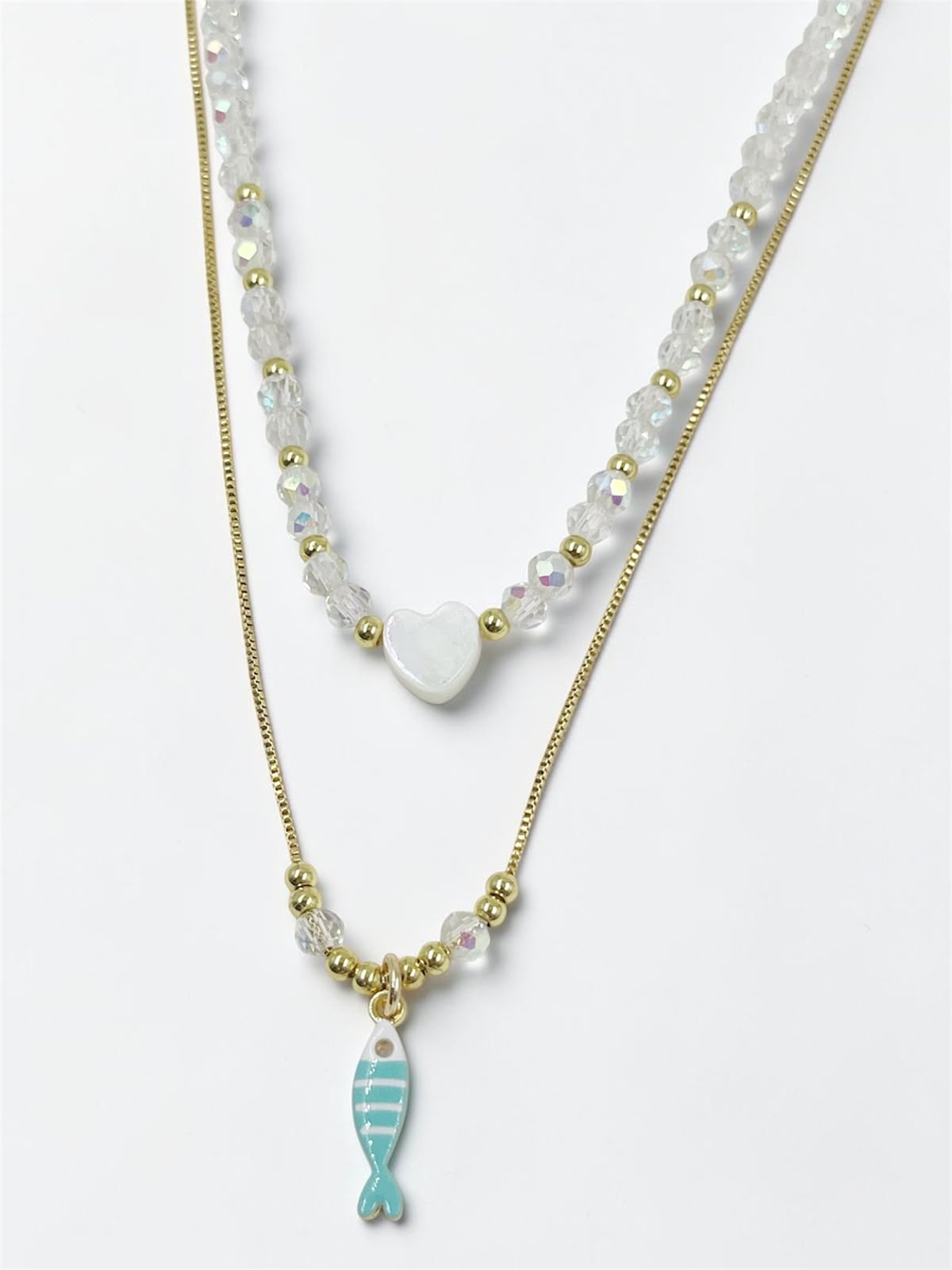 Set de dos collares con choker de cuentas y dije de corazón, acompañado de un collar largo con dije de pez para mujer.