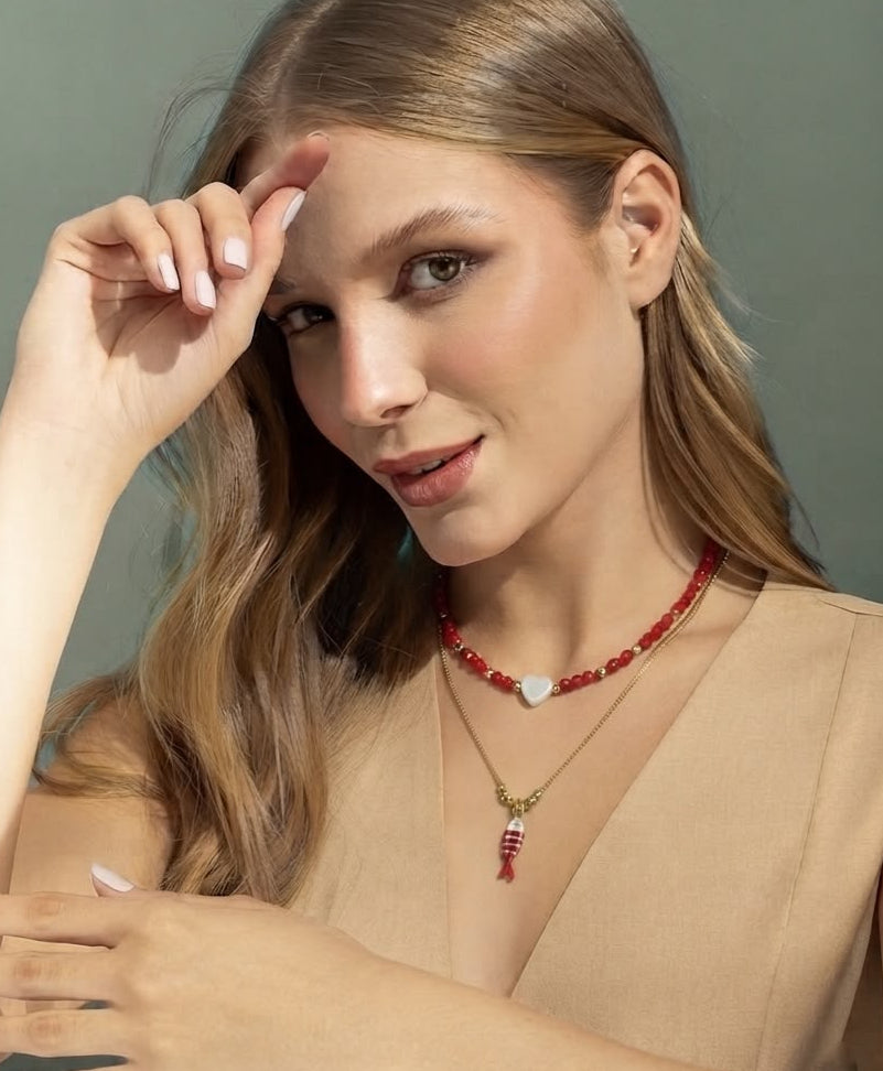 Set de dos collares con choker de cuentas y dije de corazón, acompañado de un collar largo con dije de pez para mujer.