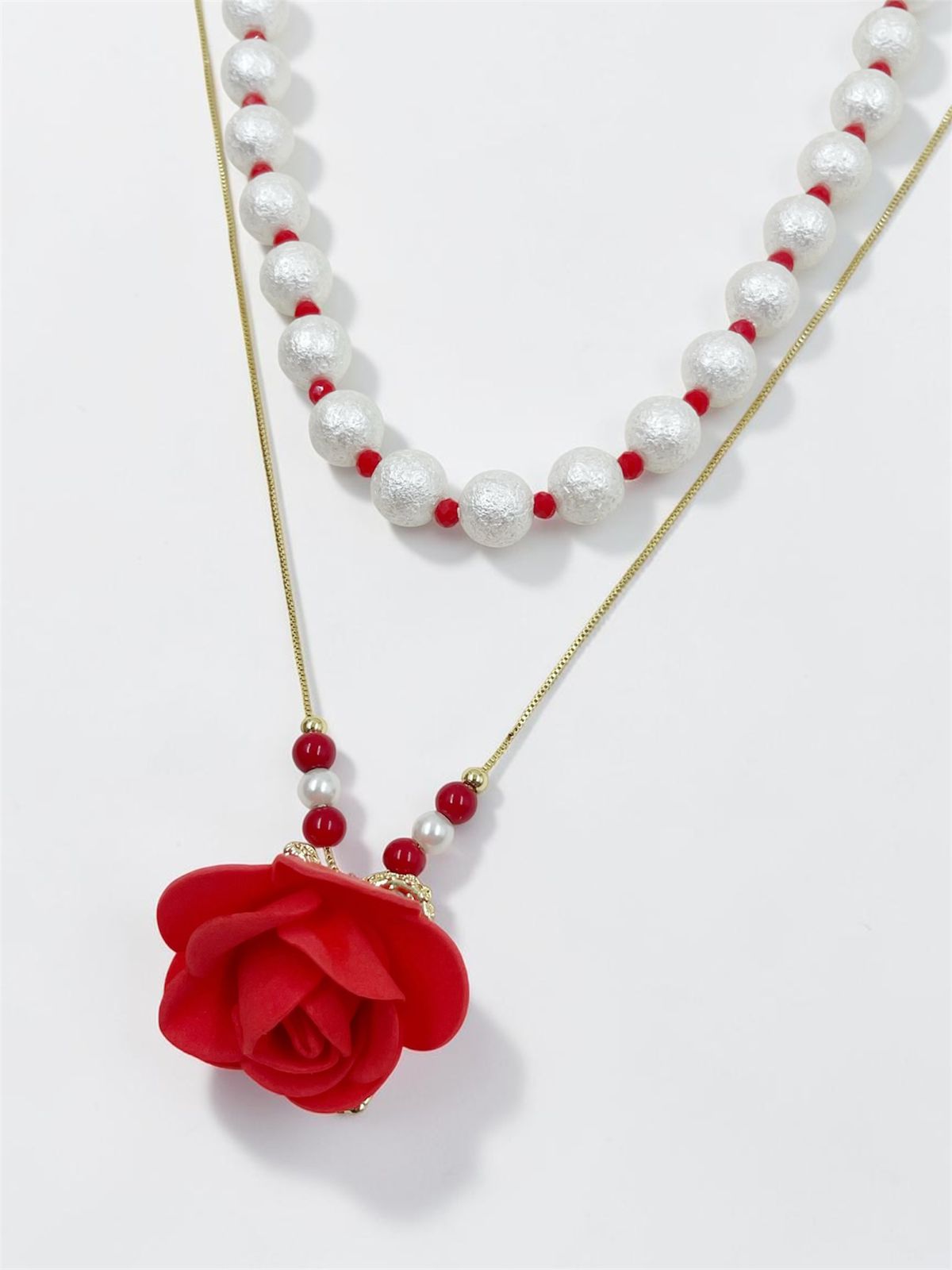 Collar Rosa Perlada de doble diseño con dije de rosa en relieve, ideal para complementar looks elegantes y casuales.