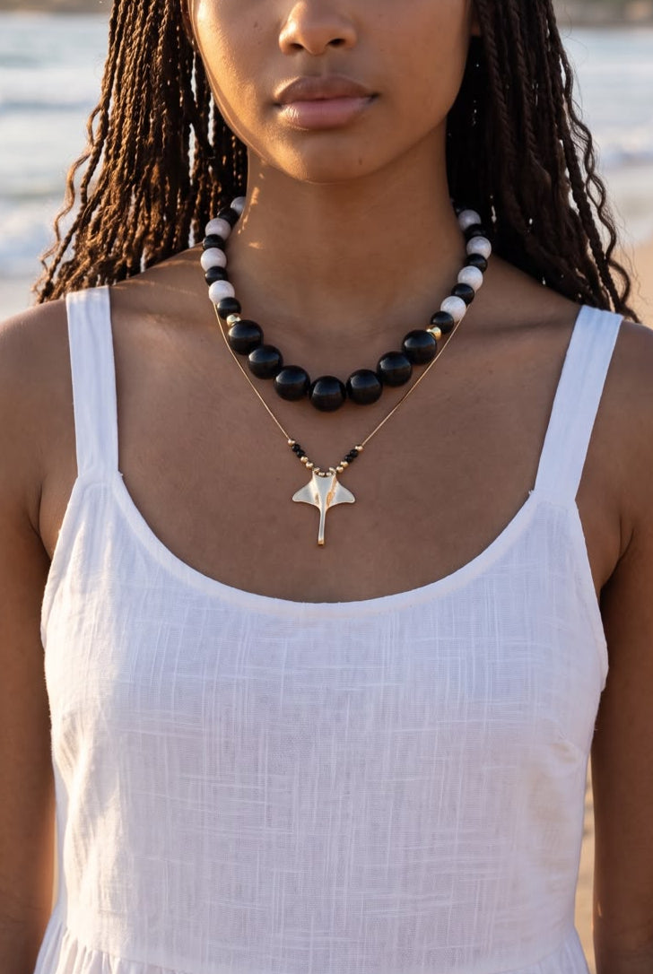 Collar con perlas de diferentes tamaños, cadena delicada y dije de manta raya.