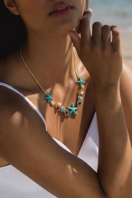 Collar Oceánico Turquesa con estrellas, conchas marinas y detalles perlados inspirado en el océano.