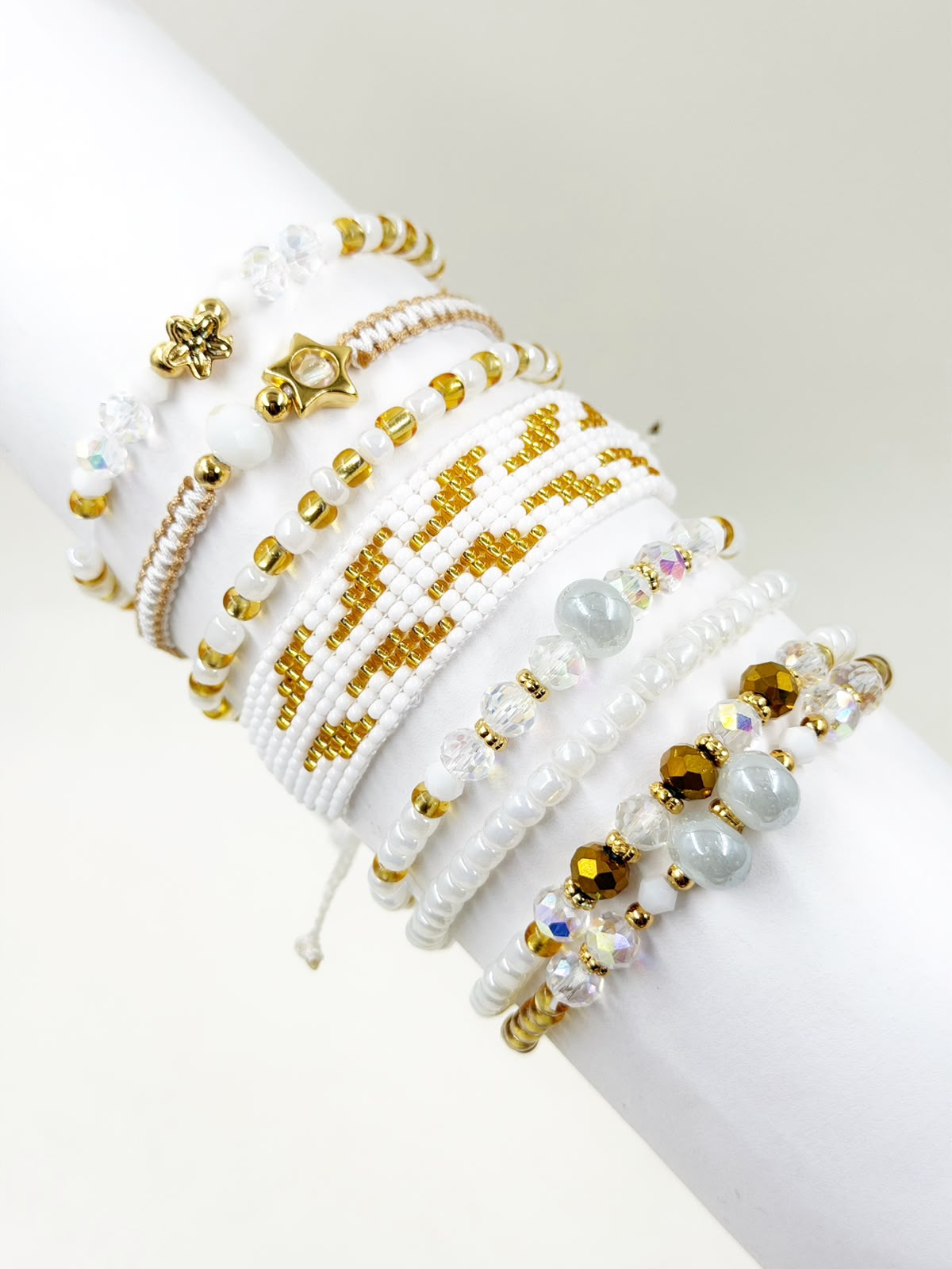 Maxipulsera blanca con detalles dorados y diseño elegante.