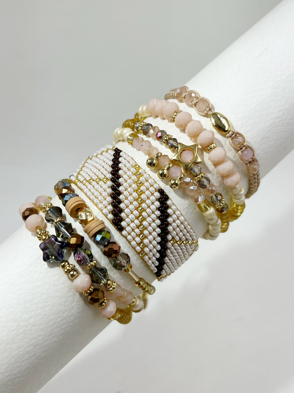 Maxipulsera de 8 vueltas con banda central tejida, cuentas facetadas, esferas de diferentes tamaños, estrella central y diseño en capas.